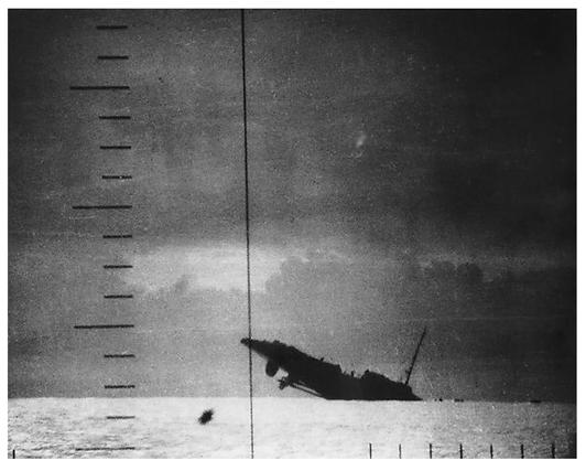 A Japanese destroyer sinks, its rudder and propellers raised out of the water, after being hit in the forward quarter by a torpedo from a U.S. submarine................................