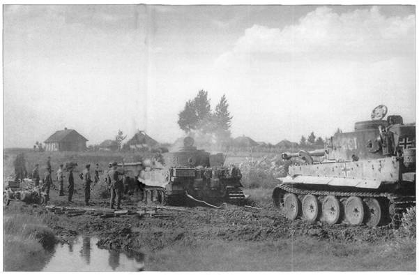 One Pz Kw VI &quot;Tiger&quot; Ausf. E trying to remove a similar vehicle from an uncomfortable situation......................................