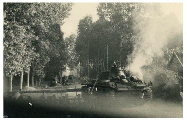 In the foreground a Pz Kw III, after overcoming a barrier, advances through a wooded area in France 1940 .......................................