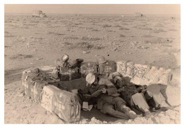 A couple of soldiers from the 15. Pz enjoy a lull in a position built with water cans.......