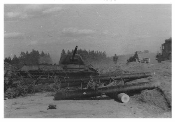 An obstacle made of logs and behind a T-34 out of combat...................................