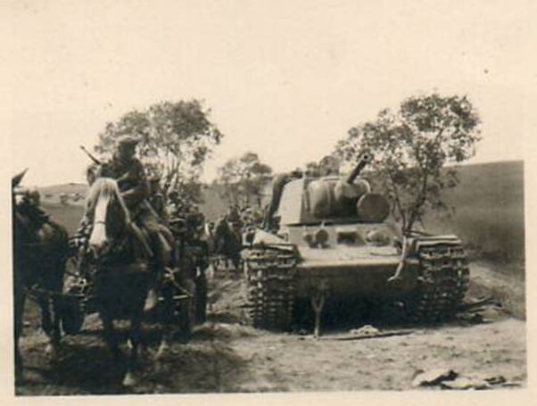 A horse-drawn German column passing next to a knocked Soviet KV 1..........................