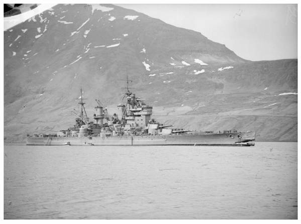 HMS KING GEORGE V, photographed with a huge hole in the bows against a mountainous backdrop,after the battleship had collided with HMS PUNJABI in dense fog on 1 May 1942, at Seidesfjord, Iceland. HMS PUNJABI was cut in half and lost. HMS KING GEORGE V was taken for repair to Gladstone dock, Liverpool (photographed from the destroyer HMS WHEATLAND).......................