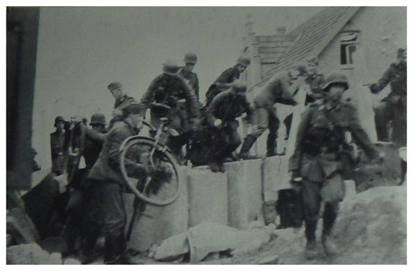 Troops on bicycles overcome a barricade in a town in the Netherlands..........................