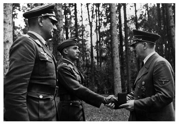 Major Walter Storp receives the Oak Leaves for the Knight's Cross from the Führer, next to him Oberstleutnant Oskar Dinort who also received the same distinction................