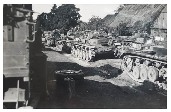 Column of Pz Kw II  stopped in a Polish village...................
