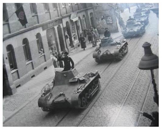Here the Chief of the 1st Company, Hauptmann Alfons Materne, in his Panzerbefehlswagen I Ausf. A. The first spectators are seen on the left and right of the street.........................................