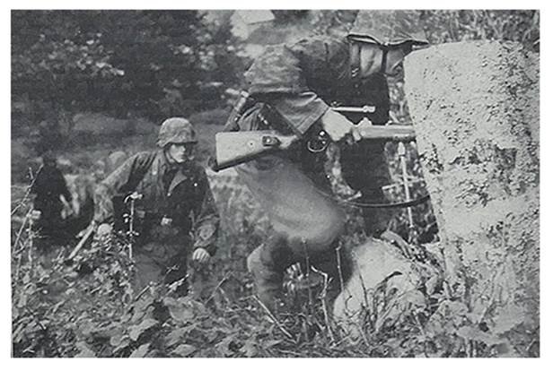 Waffen SS assault troops move in a wooded area; The soldier in the foreground carries a rifle with a telescopic sight (ZF39 Scope?)...................................
