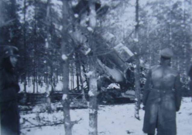 German soldiers looking at one shot down plane within a wood (may be French-German border, winter 1939-40?).
