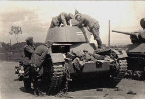 A knocked out Soviet T-26 being checked by some German soldiers (belonging to 1 Pz Group, see the white K on the bike) somewhere in Ukraine - Summer 1941.