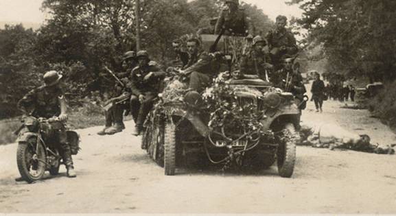 Going forward, in the foreground a Sd Kfz 10 with an antiaircraft gun and a motorcyclist