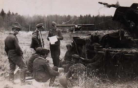 The crew of an  AA cannon of 20 mm, placed in a Sd Kfz 10, while receiving directives, in the background a Fi-156.