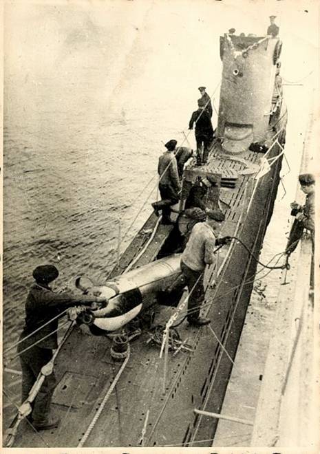 A U Boat (U 18 Type IIB) loading a drill torpedo on board, as is observed the maneuver is backwards....................