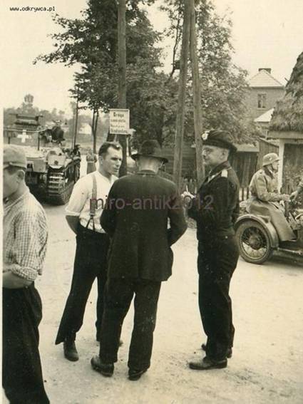 A German officer talking with civilians (volksdeutschen?) on a Polish road, the background a Panzerbefehlswagen III - Ausf.D1 .....