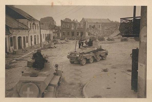 A pair of light armored vehicles passing through a locality; in the foreground a Sd Kfz 231 (8rad) and behind a Sd Kfz 232 (8rad) Funkwagen........................................