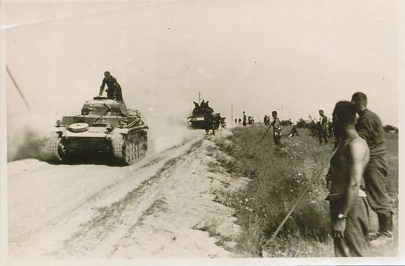 A German armored column rolling at high speed by a dusty Russian road; in the foreground a Pz Kw II ...............................