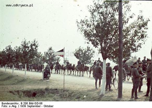 A German horse-drawn column passes next to a command post of a division (triangular tri-color pennant)..........